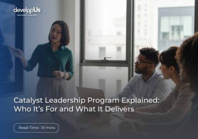 Hero image of a woman presenting to a small group in a bright office with a blue overlay and the developUs logo; title reads 'Catalyst Leadership Program Explained: Who It’s For and What It Delivers'