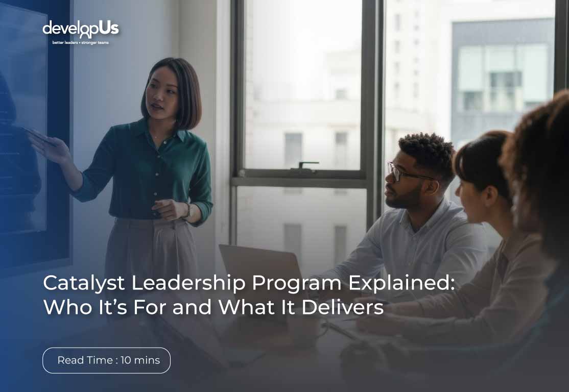 Hero image of a woman presenting to a small group in a bright office with a blue overlay and the developUs logo; title reads 'Catalyst Leadership Program Explained: Who It’s For and What It Delivers'