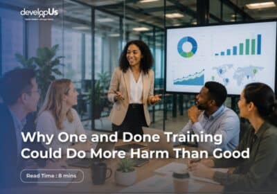 Team of four in a modern office listening to a presenter beside a large screen showing charts; overlay text reads: 'Why One and Done Training Could Do More Harm Than Good' with a 'Read Time: 8 mins' badge