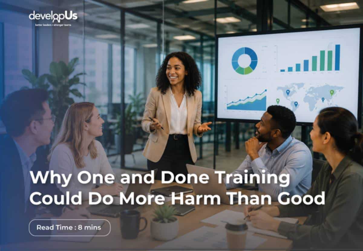 Team of four in a modern office listening to a presenter beside a large screen showing charts; overlay text reads: 'Why One and Done Training Could Do More Harm Than Good' with a 'Read Time: 8 mins' badge